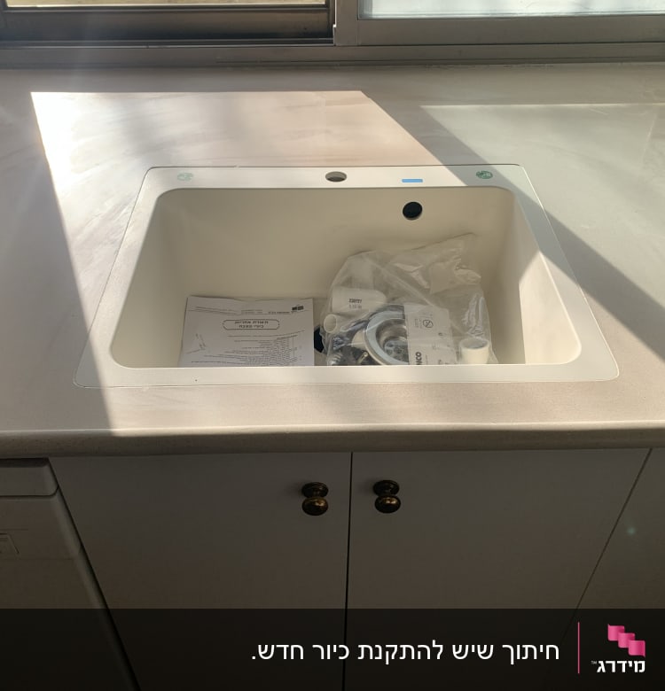 שיש בהיר עם כיור מובנה ומסמכים בתוכו